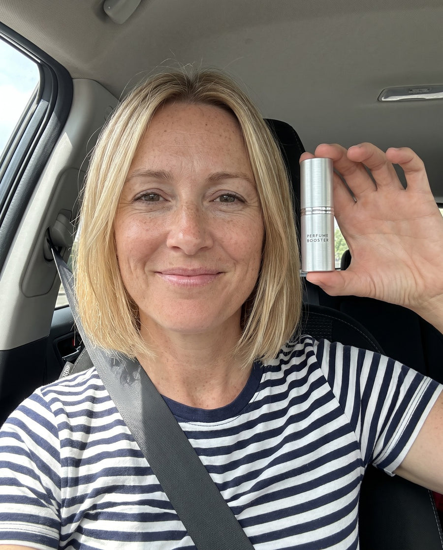 Woman holding a Perfume Booster stick in her car