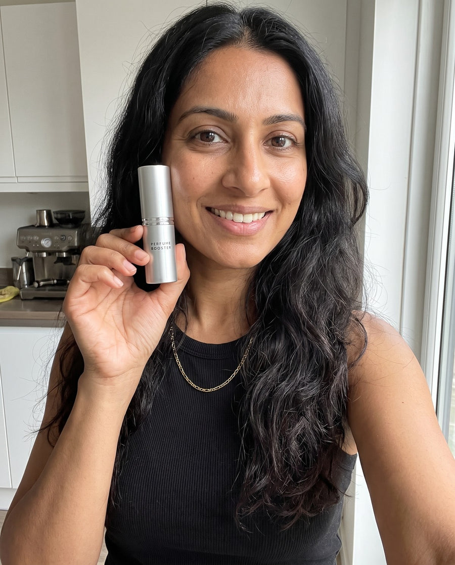 Woman holding a Perfume Booster stick in her kitchen