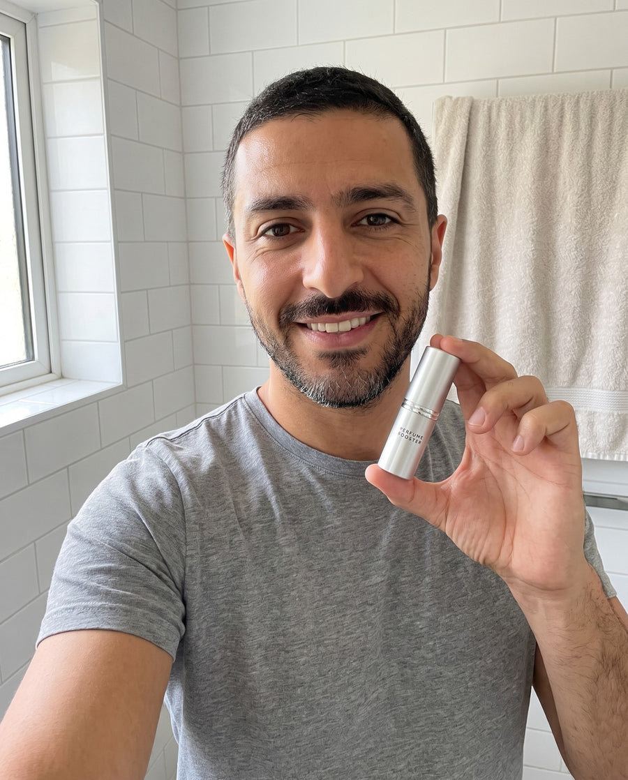 Man holding a Perfume Booster stick in his bathroom