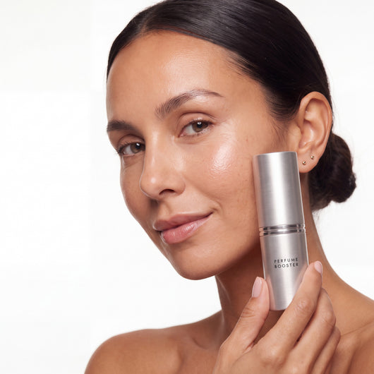 Woman holding the Perfume Booster stick next to her face